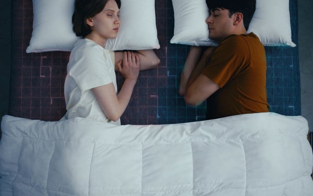 슬립큐브 커버를 씌운 매트리스에서 자는 두 사람을 위에서 본 모습